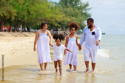 Wallpaper Mural Happy African american family holding hands and walking together on the beach during holiday. Torontodigital.ca