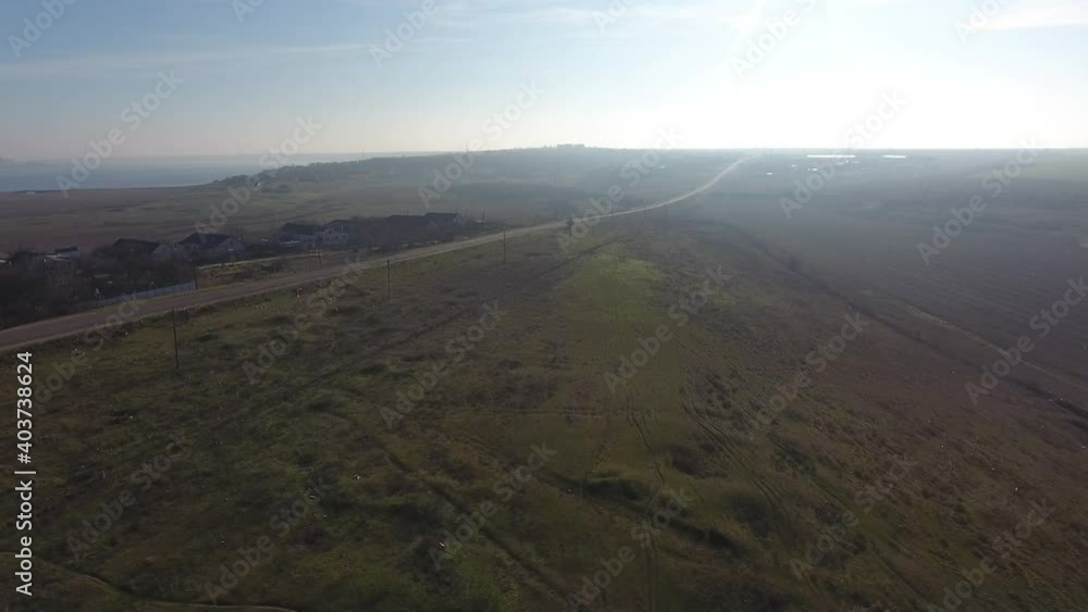 Aerial view. Morning fog. Top view of green wild meadow in front of road Aerial view. Morning fog. Top view of green wild meadow in front of road