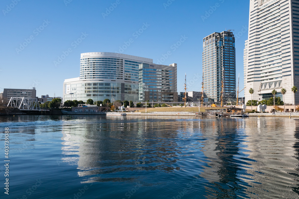 Obraz premium 日本の横浜の街。海の上から見た公園と建物の風景。