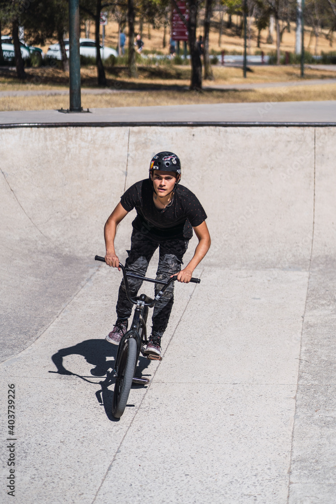 Obraz premium Latin man on bicycle in urban park. outdoor activity concept
