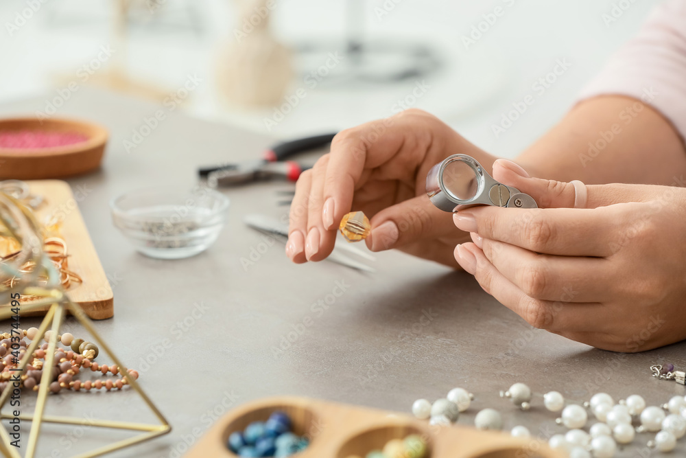 Female designer making jewelry at workplace Female designer making jewelry at workplace