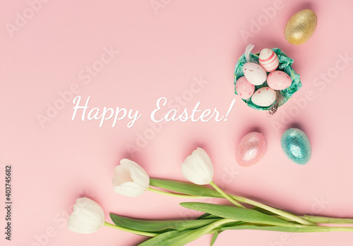 Easter greeting card with colorful easter eggs on pink background. Top view, flat lay with space for your text.