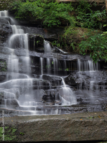 Rocky waterfall cascade with tree.