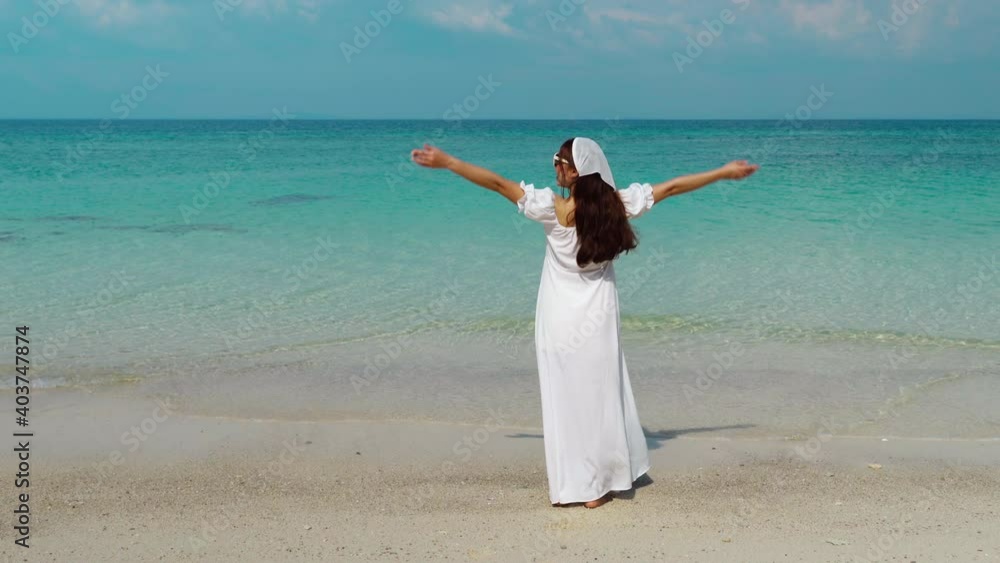 cheerful woman walking and arm raised on the sea beach at Koh MunNork Island, Rayong, Thailand cheerful woman walking and arm raised on the sea beach at Koh MunNork Island, Rayong, Thailand