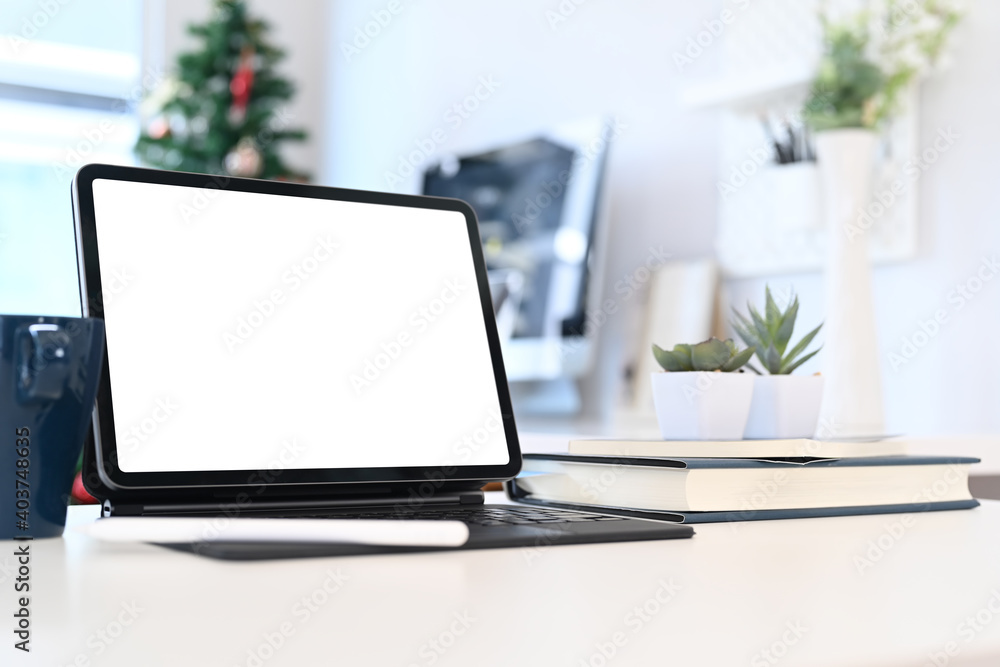 Comfortable workplace with tablet computer, notebook, coffee cup, and plant. Blank screen for graphic display montage. Comfortable workplace with tablet computer, notebook, coffee cup, and plant. Blank screen for graphic display montage.