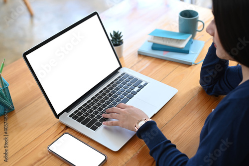 Cropped shot of young female freelancer working with laptop computer at her workspace.