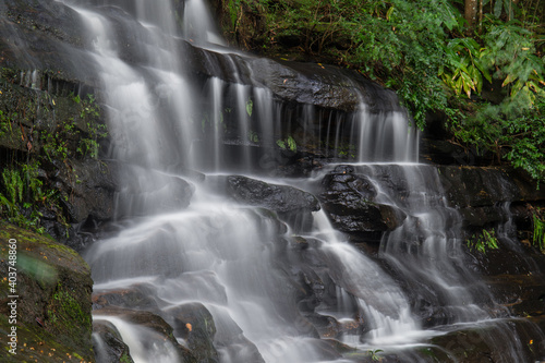 Close-up view of waterfall with tree around it.