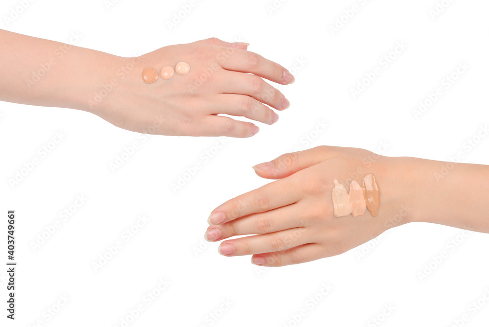 Fair, medium, dark swatches  of foundation on the hand isolated on white.