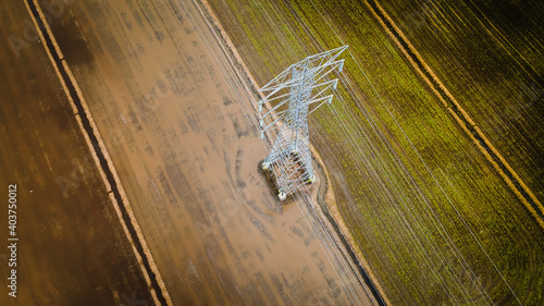 National Electricity grid from top view with Abstract. Aerial view of power line pylon in open paddy field.