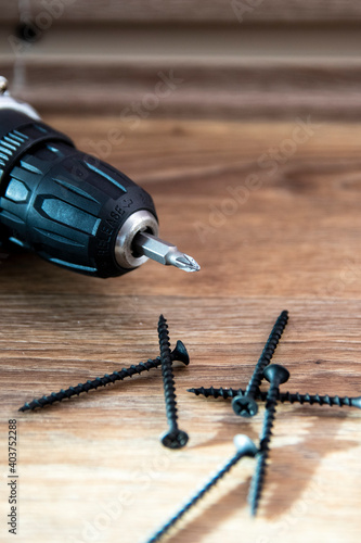 Self-tapping screws with a cordless drill. Selective focus. The concept of tools and repair work.