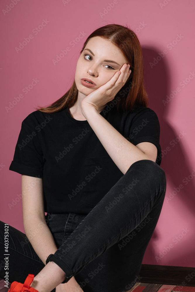 Girl in black poses on a pink background. Girl in black poses on a pink background.