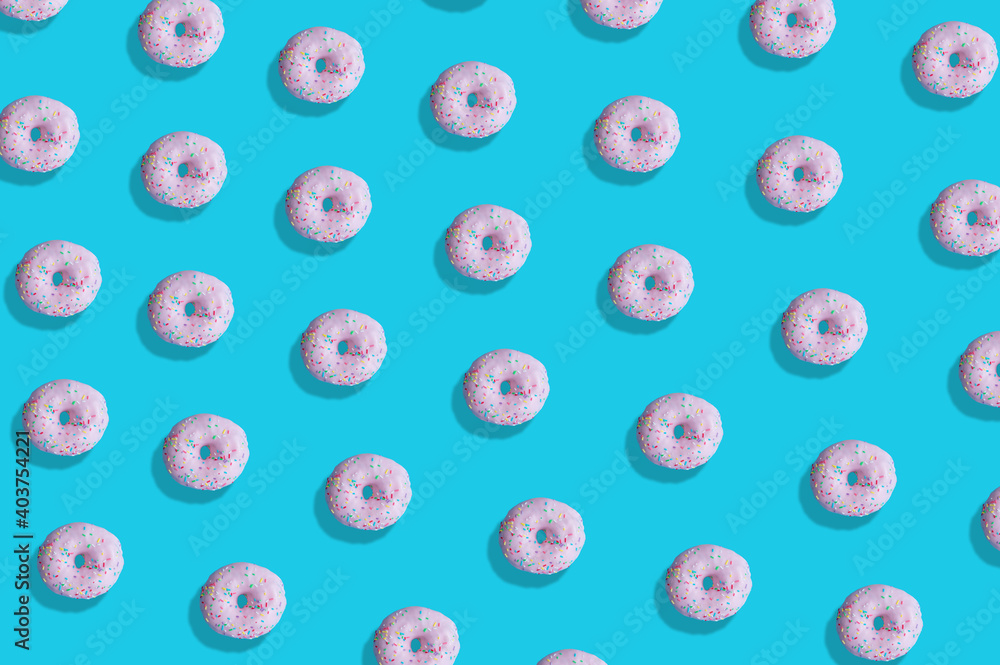 Creative pattern made of pink donuts on pastel blue background. Minimal flat lay food concept Creative pattern made of pink donuts on pastel blue background. Minimal flat lay food concept