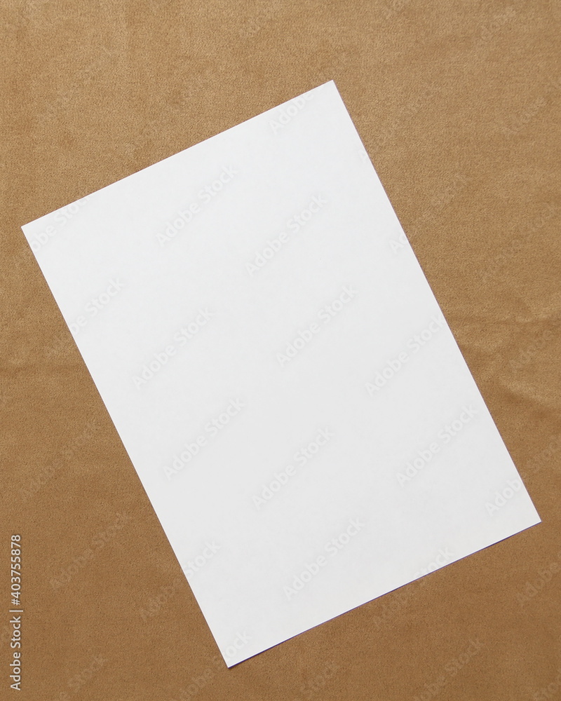 Template of white paper lies diagonally on light brown cloth background. Concept of business plan and strategy. Stock photo with empty space for text and design. Template of white paper lies diagonally on light brown cloth background. Concept of business plan and strategy. Stock photo with empty space for text and design.