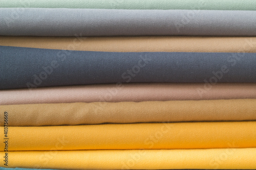 Multicolored fabrics folded in a stack top view on a white background. Multi-colored textile	
