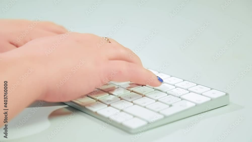 Male hands are typing on a white wireless keyboard. Medium plan Male hands are typing on a white wireless keyboard. Medium plan