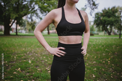 Young woman core sport suit do the workout plays sports in the park outside playground