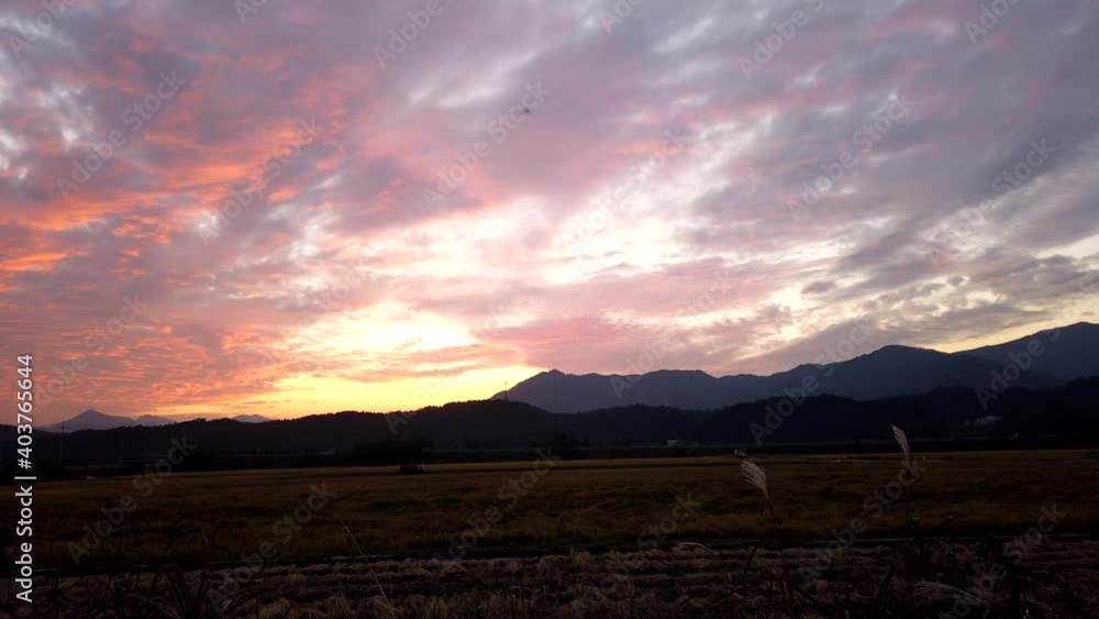 Beautiful Dramatic Fast Time lapse of Sunset and Clouds in the Orange Twilight Sky. The Sunsets Over the Horizon on the Field in countryside. Beautiful Dramatic Fast Time lapse of Sunset and Clouds in the Orange Twilight Sky. The Sunsets Over the Horizon on the Field in countryside.