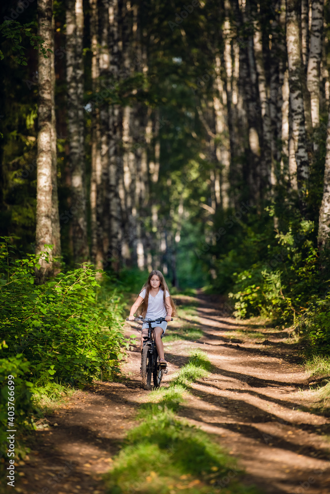 Children girl riding bicycle outdoor in forest smiling. Children girl riding bicycle outdoor in forest smiling.