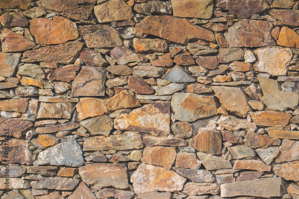 Old stone rock wall surface texture with grass. Close up detail. Pattern abstract background. Old stone rock wall surface texture with grass. Close up detail. Pattern abstract background.