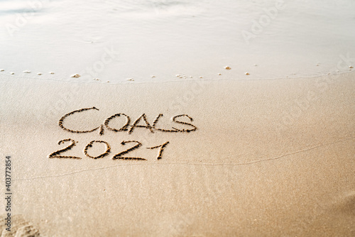 foamy sea water and Inscription Goals 2021 on the sandy beach