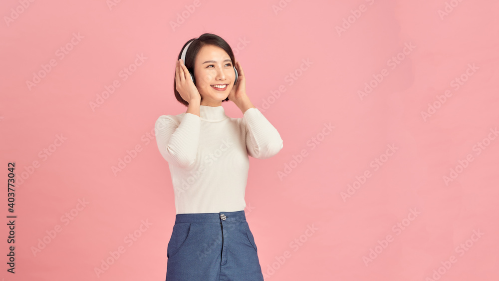 Happiness Asian smiling young woman wearing technology wireless headphones for listening the music via smart mobile phone Happiness Asian smiling young woman wearing technology wireless headphones for listening the music via smart mobile phone