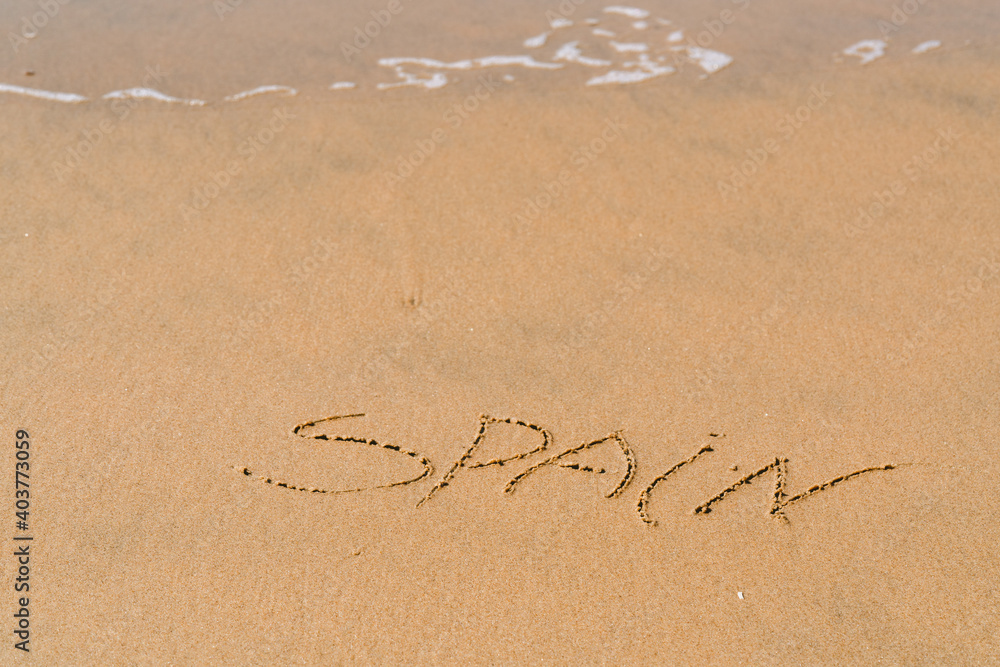 Fototapeta premium Spain inscription on the sea sand