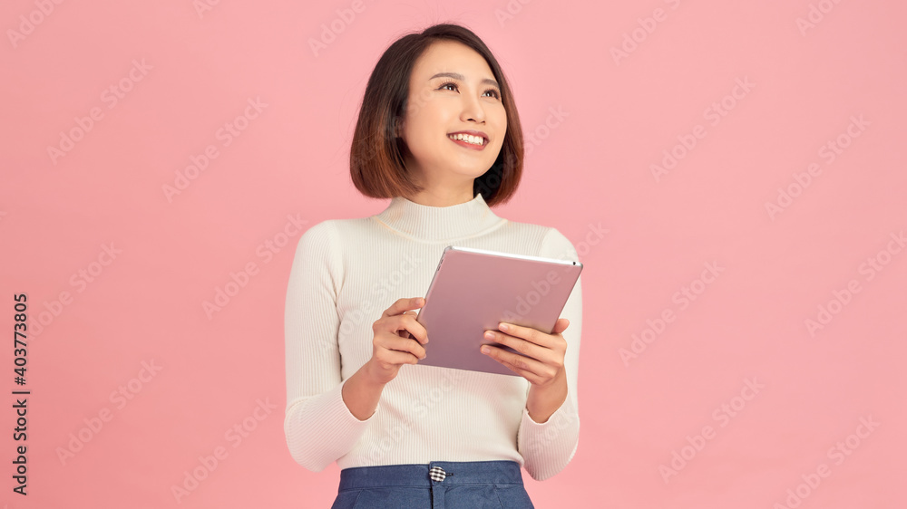 Beauty at work. Confident young women holding digital tablet while standing against pink background Beauty at work. Confident young women holding digital tablet while standing against pink background