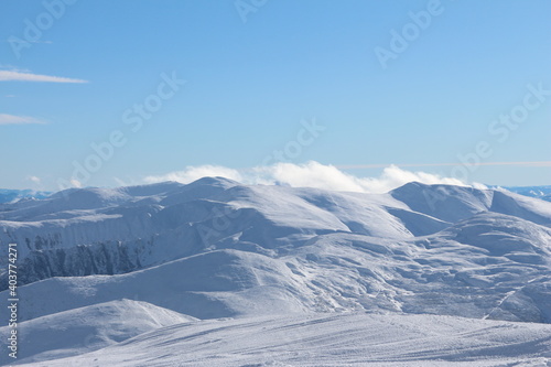White clouds above the snow covered mountains