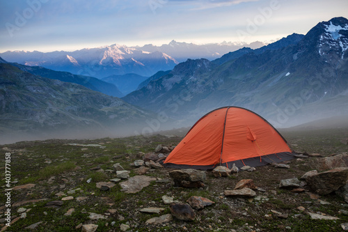Base camp set in Alpine background. Ten set on hill i Alps mountains. Tourist shelter camp in high mountains.