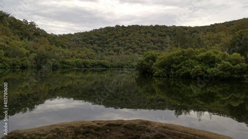 Beautiful river with reflections of mountains, trees and cloudy sky on water, Crosslands Reserve, Berowra Valley National park, Sydney, New South Wales, Australia
 photo