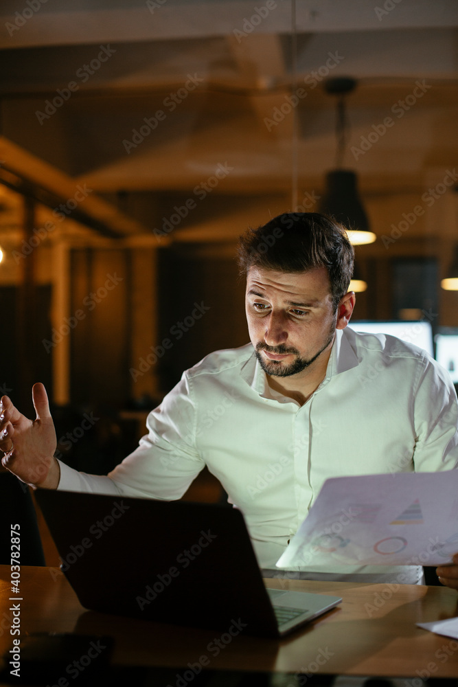 Young businessman working with laptop at office. Businessman sitting at office desk working on laptop computer..