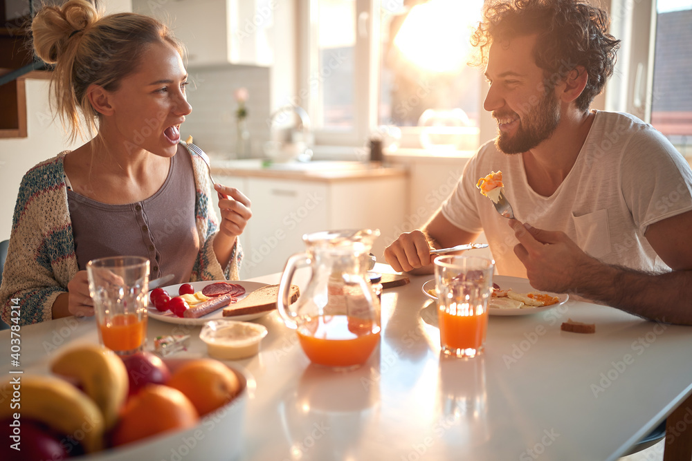 A young couple in love eating breakfast at home. Relationship, love, together, breakfast A young couple in love eating breakfast at home. Relationship, love, together, breakfast