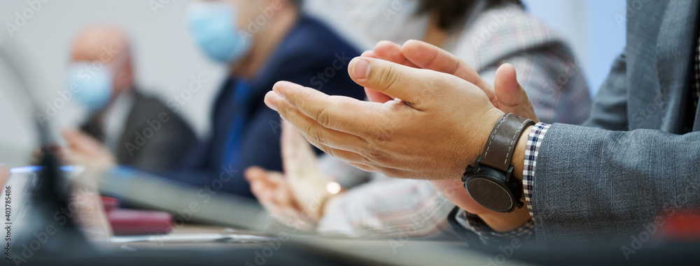A man participating in a meeting or negotiation expresses his agreement with the decision or speech with the help of applause. Close-up. Banner. A man participating in a meeting or negotiation expresses his agreement with the decision or speech with the help of applause. Close-up. Banner.