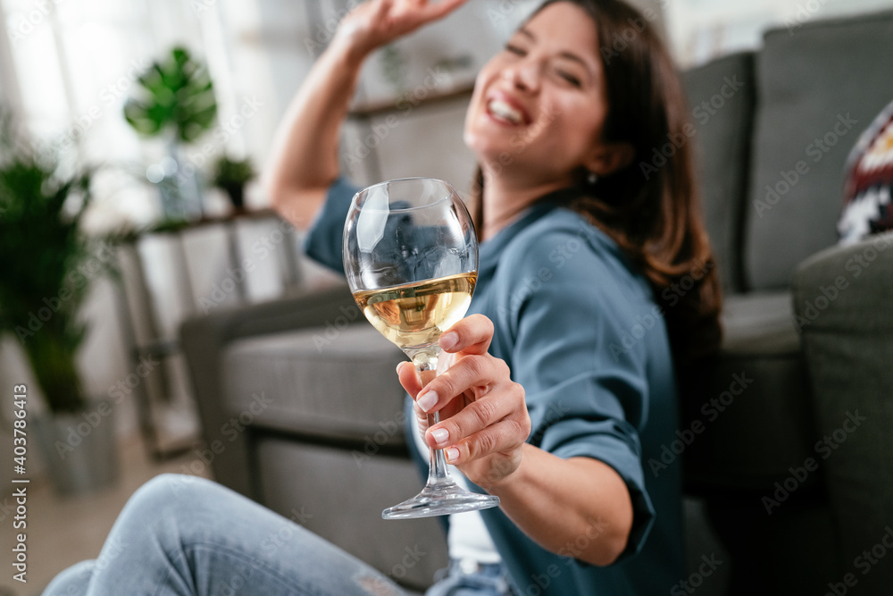 Beautiful woman sitting on the floor, drinking wine. Young woman celebrate with wine at home. Beautiful woman sitting on the floor, drinking wine. Young woman celebrate with wine at home.