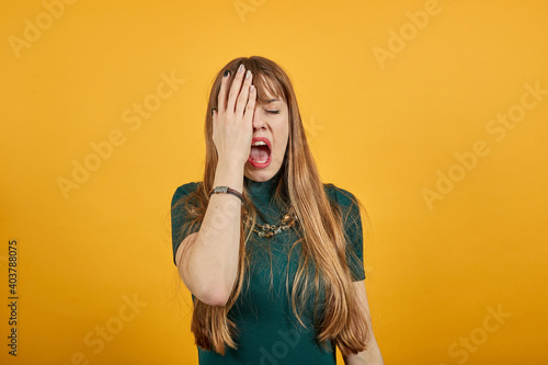Covering eyes with hand but peeking through fingers. My eye see everything. Studio shot of sincere pretty caucasian, I can not hold promise. Charming playful. Wanting to distinguish surprise.