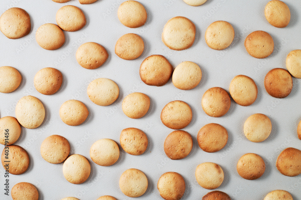 A pattern of small pancakes. Background from orange toasted round biscuits. home bakery A pattern of small pancakes. Background from orange toasted round biscuits. home bakery