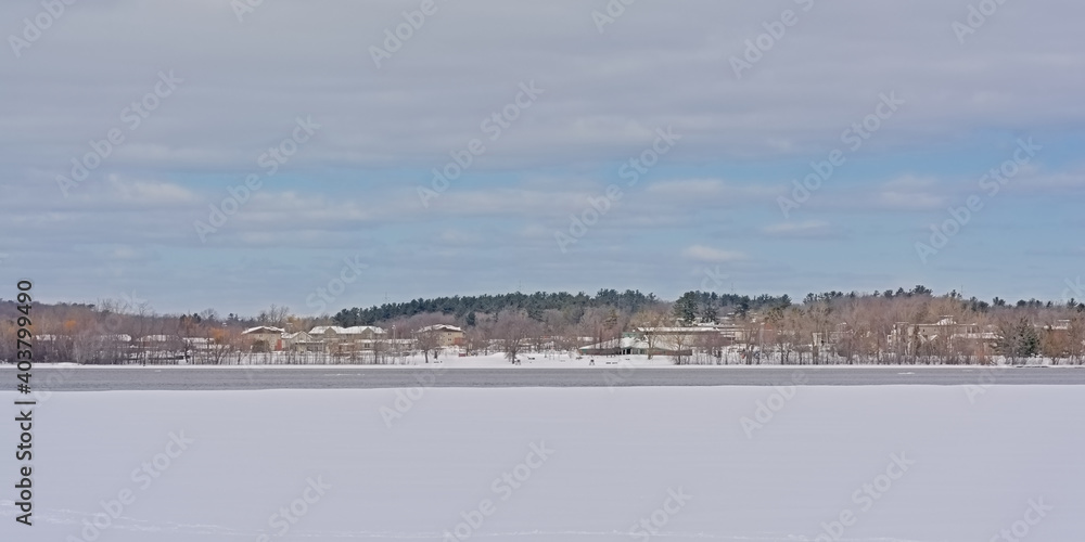 Cost of hull along Ottawa river with ice and snow on a sunny winter day withcloudy sky in Gatineau, Canada 
