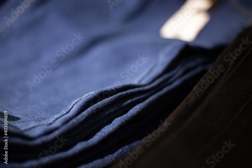 Stack of blue and black jeans in a shop. Concept of buy, sell, shopping and jeans fashion.