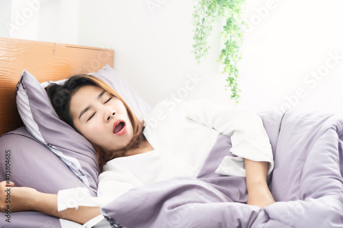 Asian woman snoring and open mouth while sleeping in bed