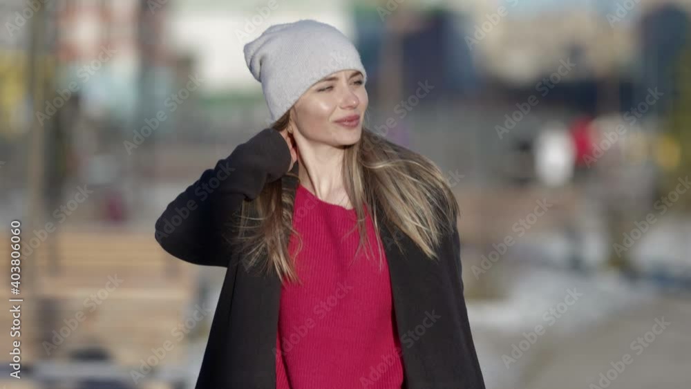 Portrait of a fashionable young smiling woman in a coat and hat walking and posing on a city street. Autumn, winter fashion. Portrait of a fashionable young smiling woman in a coat and hat walking and posing on a city street. Autumn, winter fashion.