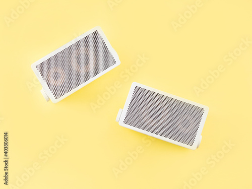 Retro gray audio music speakers on bright yellow background. Flat lay