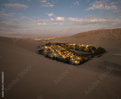 Panoramic postcard view of Huacachina oasis town village desert dry sand dunes texture pattern Ica Peru South America photo