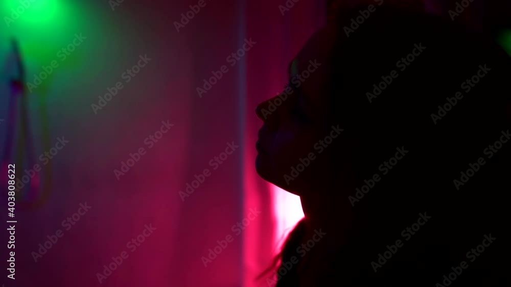young sad woman in room with neon lights at night, slow motion, medium shot young sad woman in room with neon lights at night, slow motion, medium shot