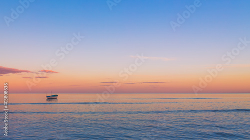 boat on calm ocean at sunset, background