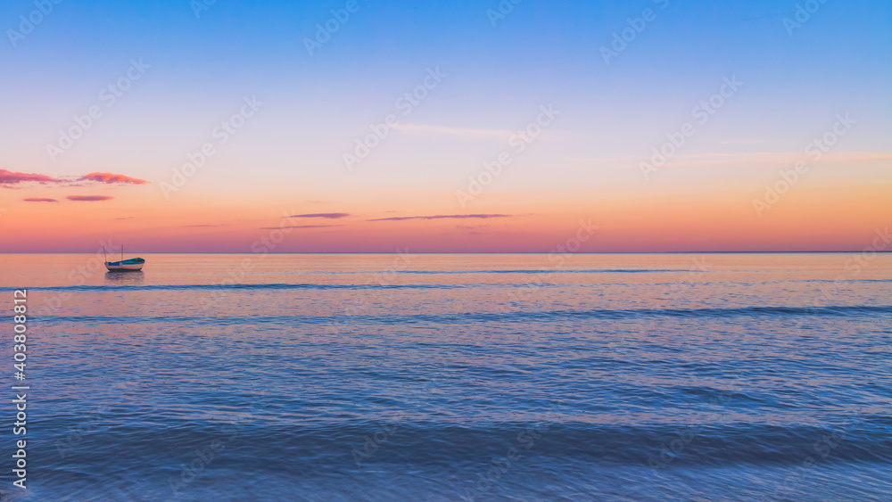 boat on calm ocean at sunset, background