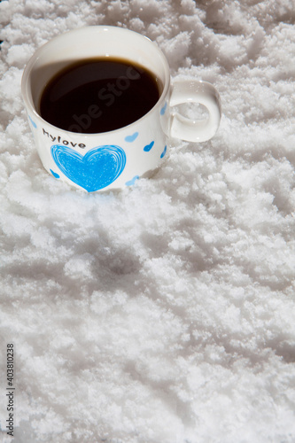 Glass Tea Cup In Snow. Heart as a romantic symbol of love