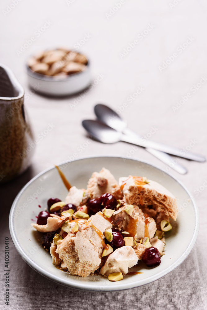 Not traditional Eton mess. Meringue, pistachio, cherry and caramel sauce dessert. Selective focus Not traditional Eton mess. Meringue, pistachio, cherry and caramel sauce dessert. Selective focus