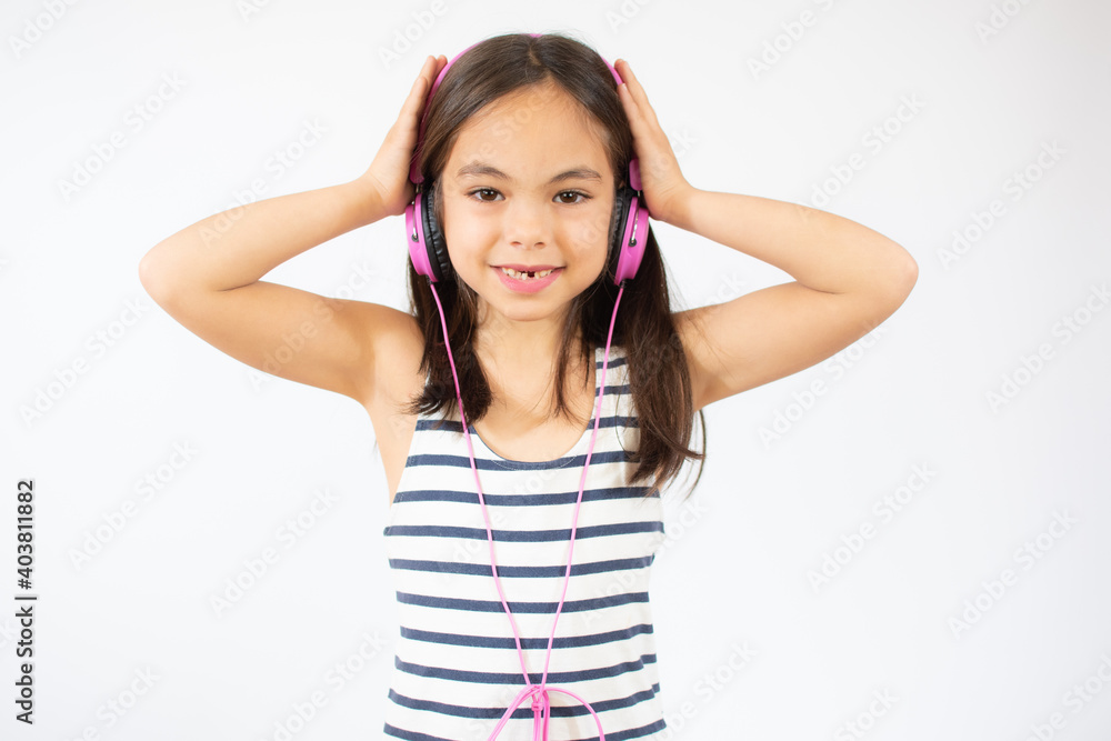 Beautiful cute happy little girl with headphones over white background. Beautiful cute happy little girl with headphones over white background.