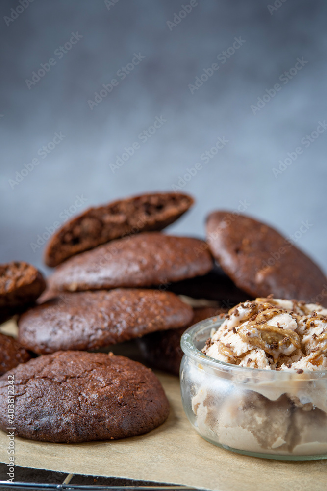 Pile of fluffy chocolate brownie cookies served with peanut butter ice cream in a glass jar. Healthy homemade gluten free chocolate chip cookies on a cooling rack. Pile of fluffy chocolate brownie cookies served with peanut butter ice cream in a glass jar. Healthy homemade gluten free chocolate chip cookies on a cooling rack.
