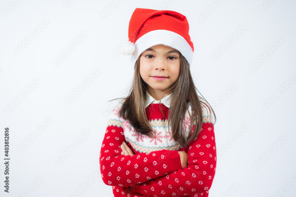 Beautiful little girl in santa hat with arms folded over white background. Beautiful little girl in santa hat with arms folded over white background.